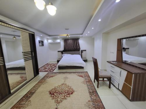 um quarto com uma cama, um toucador e um espelho. em شقه فندقيه بالدقي no Cairo