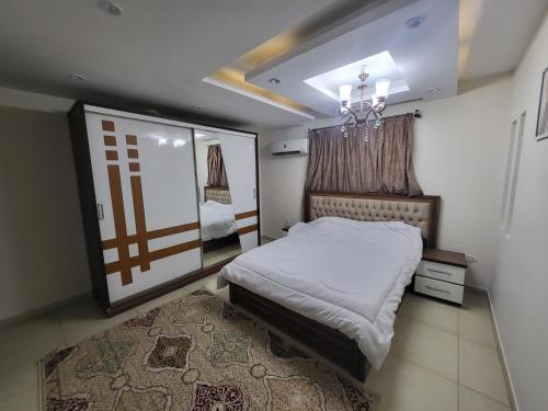 1 dormitorio con cama y lámpara de araña en شقه فندقيه بالدقي en El Cairo