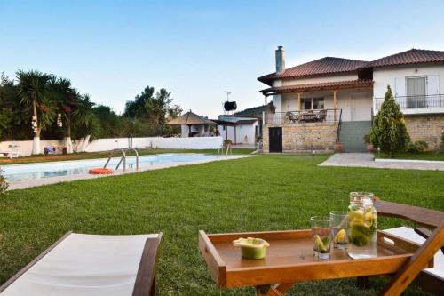 stół z szklankami obok podwórka w obiekcie Villa John Dimeon Kato Achaia With Pool - Happy Rentals w mieście Patras