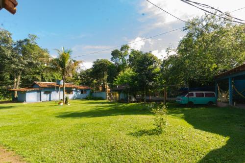 a yard of a house with a car parked in it at Hostel e Camping Jardim da Mata in Chapada dos Guimarães