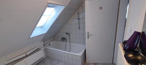 a bathroom with a bath tub and a window at Antony Home Ferienwohnung in Ostrach