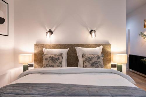 a bedroom with a large bed with two lamps at Quartier Notre Dame in Paris