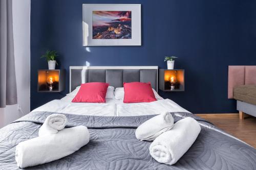 a bedroom with a large bed with towels on it at Wonderful Apartments in the Center of Krakow in Kraków