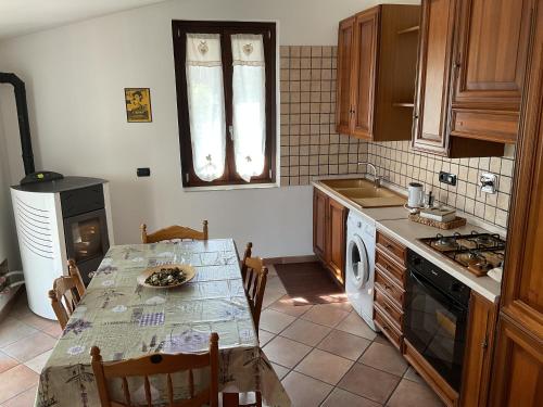 Villar Dora的住宿－Bed & Breakfast Il PIGNOMO，厨房配有桌子和炉灶。 顶部烤箱