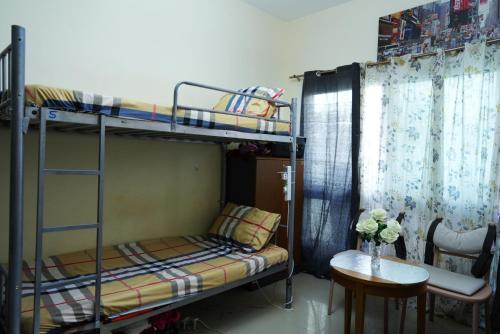 a room with two bunk beds with a table and a chair at Women Only Hostel near Burjuman Metro exit 4 in Dubai