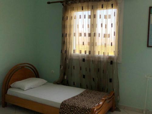 a small bedroom with a bed and a window at Ammodares in Lixouri