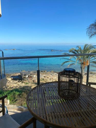a wooden table with a view of the ocean at Attico fronte mare Espardell19 Es Pujols in Es Pujols