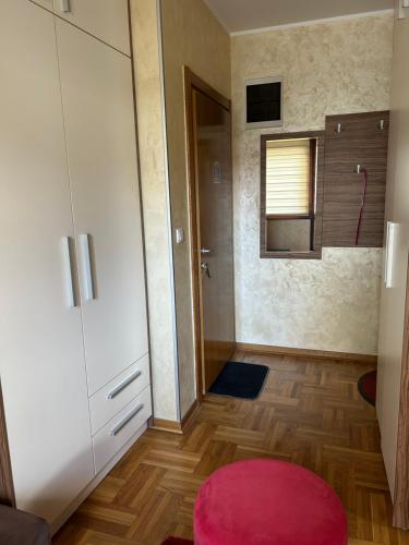a room with a white cabinet and a red rug at Zlatiborski konaci- apartman Katarina in Zlatibor