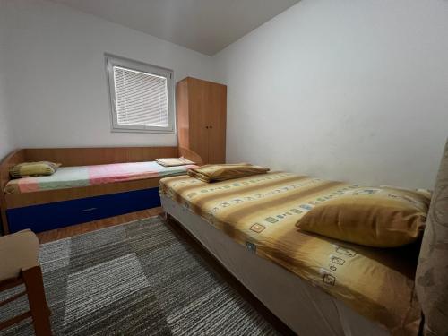1 Schlafzimmer mit 2 Betten und einem Fenster in der Unterkunft Dvosoban kompletno sredjen stan in Tivat