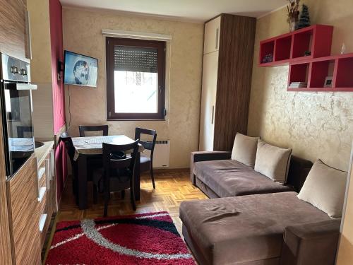 a small living room with a couch and a table at Zlatiborski konaci- apartman Katarina in Zlatibor