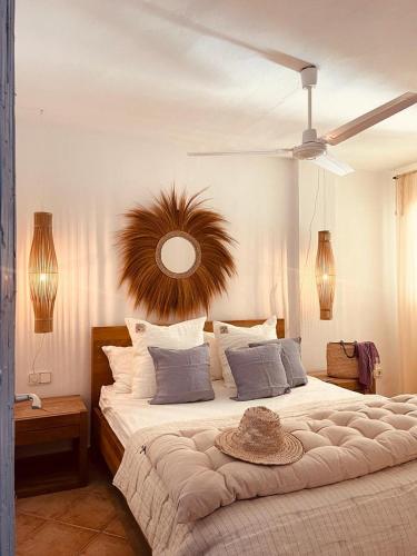 a bedroom with a large bed with a hat on it at Attico fronte mare Espardell19 Es Pujols in Es Pujols