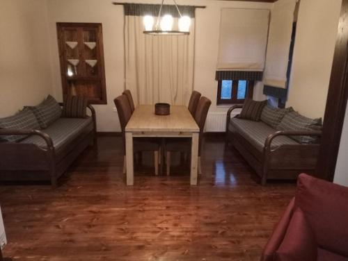 uma sala de estar com uma mesa e um sofá em Τείχιο Πατρικό - Tihio Patriko - Πέτρινη κατοικία em Tíkhion