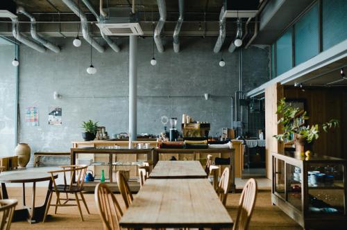 a restaurant with tables and chairs and a kitchen at Hostel Saruya in Fujiyoshida