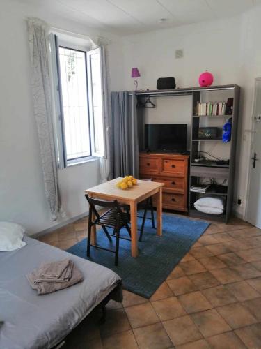 Cette chambre comprend une table, un lit et une télévision. dans l'établissement Ideal studio à 50 m des plages du mourillon, à Toulon