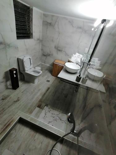 a bathroom with a sink and a toilet and a mirror at Anastasia's Apartment ΛΑΥΡΙΟ in Lávrion