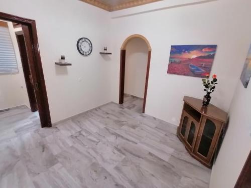 a room with a clock on the wall and a table at Anastasia's Apartment ΛΑΥΡΙΟ in Lávrion
