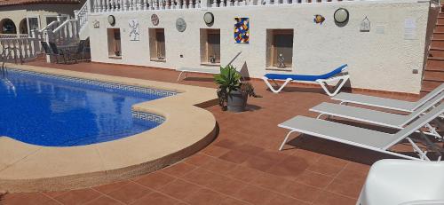 einen Pool mit zwei Liegestühlen neben einem Gebäude in der Unterkunft Casa Gran Vista, Studio, Adults only in Jalón