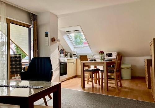 a living room with a table and a kitchen at Ferienwohnung Neubacher in Uhldingen-Mühlhofen