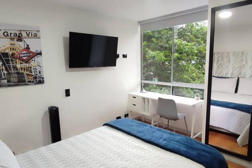 a bedroom with a bed and a desk and a window at Wonderful Apartament 7 Floor Viamonti in Medellín