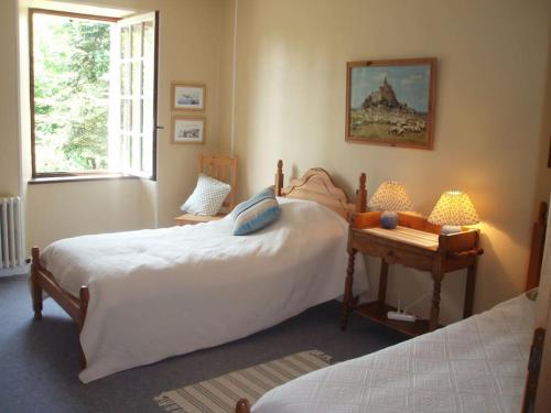 1 dormitorio con 2 camas, mesa y ventana en Magnificent French Country House with Private Heated Pool & Gardens, en Quettreville-sur-Sienne
