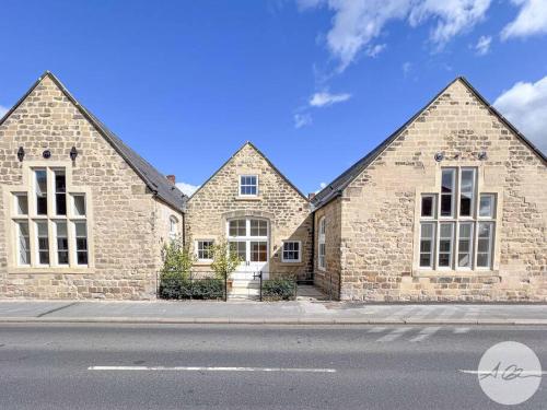 a large brick house with white windows on a street at Exceptional Holiday Home 7 in Pickering with Hot Tub in Pickering