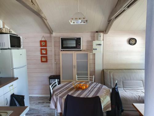 - une petite chambre avec une table et des oranges dans l'établissement Chalet et caravane sur terrain privé , mer à pied, à Pénestin