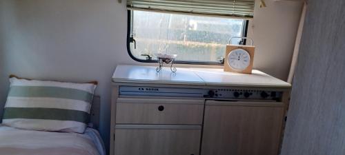 une petite cuisine avec un évier et une fenêtre dans l'établissement Chalet et caravane sur terrain privé , mer à pied, à Pénestin