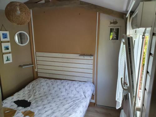 une chambre avec un lit dans une petite pièce dans l'établissement Chalet et caravane sur terrain privé , mer à pied, à Pénestin