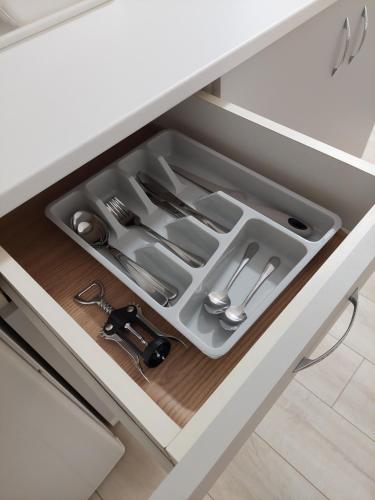 a drawer in a kitchen cabinet with utensils at Sobe Tanja in Subotica