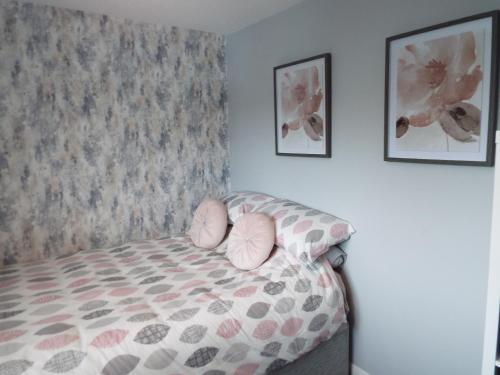 a bedroom with a bed with pink pillows on it at Modern 2 Bed in Troon in Loans