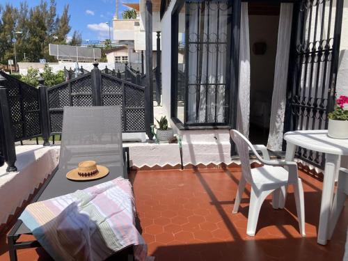 un patio con 2 sillas, una mesa y un sombrero en Apartamento La Mimosa, en San Agustín