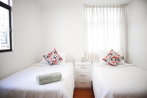 2 Betten in einem Zimmer mit Fenster in der Unterkunft HISTORIC CENTER PERUVIAN CLASIC Apartment in Lima