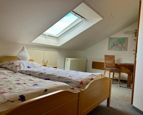 a bedroom with a bed and a skylight at Ferienwohnung Neubacher in Uhldingen-Mühlhofen