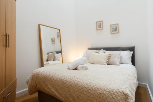 a bedroom with a bed with a large mirror at Cozy Downtown Loft in Bradford in Bradford