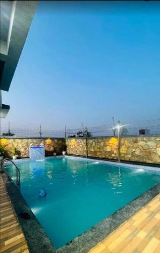 a large swimming pool with blue water at 2 bhk with private pool in Thūr
