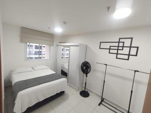 um quarto branco com uma cama e uma ventoinha em Lindo apart. estrutura de hotel em Brasília