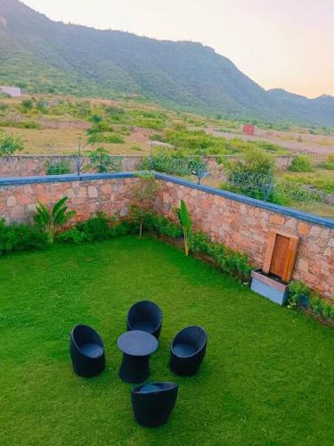 a group of stools sitting on the grass in a yard at 2 bhk with private pool in Thūr