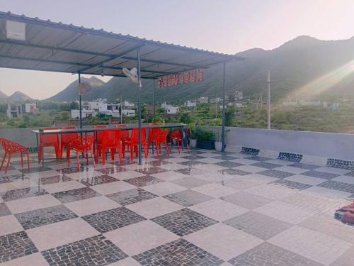 eine Terrasse mit roten Stühlen und einem Tisch mit Aussicht in der Unterkunft 2 bhk with private pool in Thūr