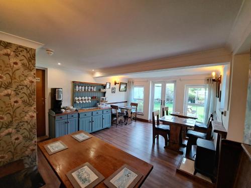 a kitchen with a table and a dining room at The Red Lion Country Inn, B&B, Llew Coch B&B in Llanfihangel-nant-Melan
