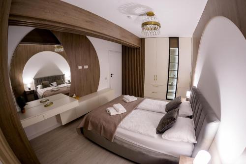 a bedroom with a large bed and a large mirror at Prime Apartments City Centre 48 in Suceava