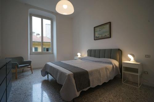ein Schlafzimmer mit einem Bett, einem Stuhl und einem Fenster in der Unterkunft Manzoni 22 in La Spezia