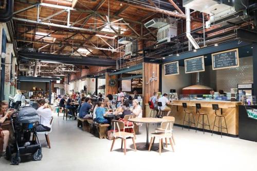 a group of people sitting at tables in a restaurant at Cozy Studio Bungalow Steps To Armature Works in Tampa