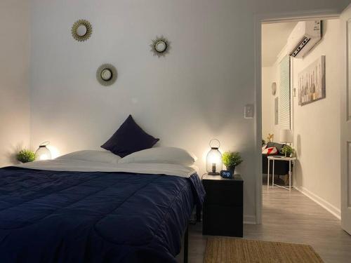 - une chambre avec un lit bleu et un mur blanc dans l'établissement Cozy Studio Bungalow Steps To Armature Works, à Tampa