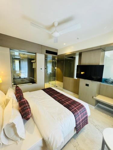 a bedroom with a large bed and a flat screen tv at InstaFeel Hotel in Navi Mumbai