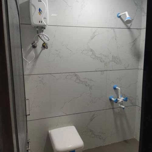 a bathroom with a toilet and a marble wall at Juli villa in Daman