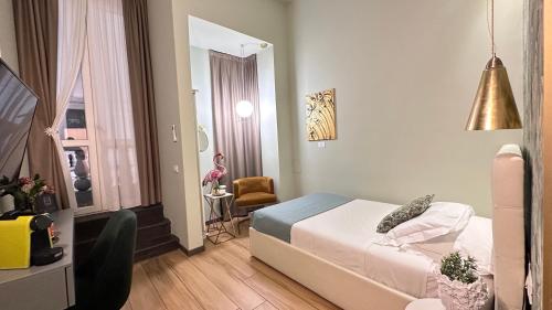 a small room with a bed and a chair in it at INTOMILAN Galleria Duomo I Boutique & Design Aparthotel in Milan
