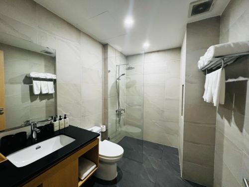 a bathroom with a toilet and a sink and a shower at Bibi’s home in Danang