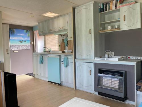 eine Küche mit weißen Schränken und einem Kamin in der Unterkunft Aqua Beach House in Oudehaske