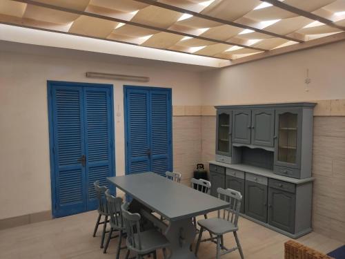 una cucina con porte blu e tavolo e sedie di Casa Lido degli Angeli a 120m dal mare a Punta Prosciutto