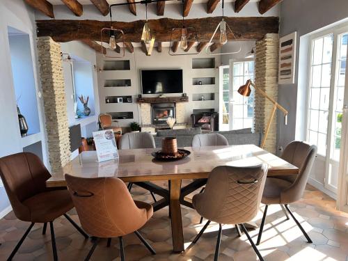 a dining room with a wooden table and chairs at STNAHOME 60110 Maison Champêtre aux Portes de Paris in Amblainville